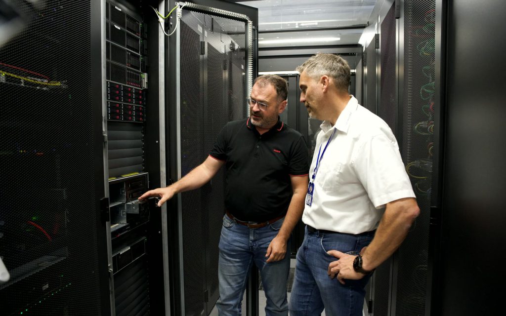 Wolfgang Asbeck zeigt Bernhard Schlögl einen Server im Rechenzentrum München.