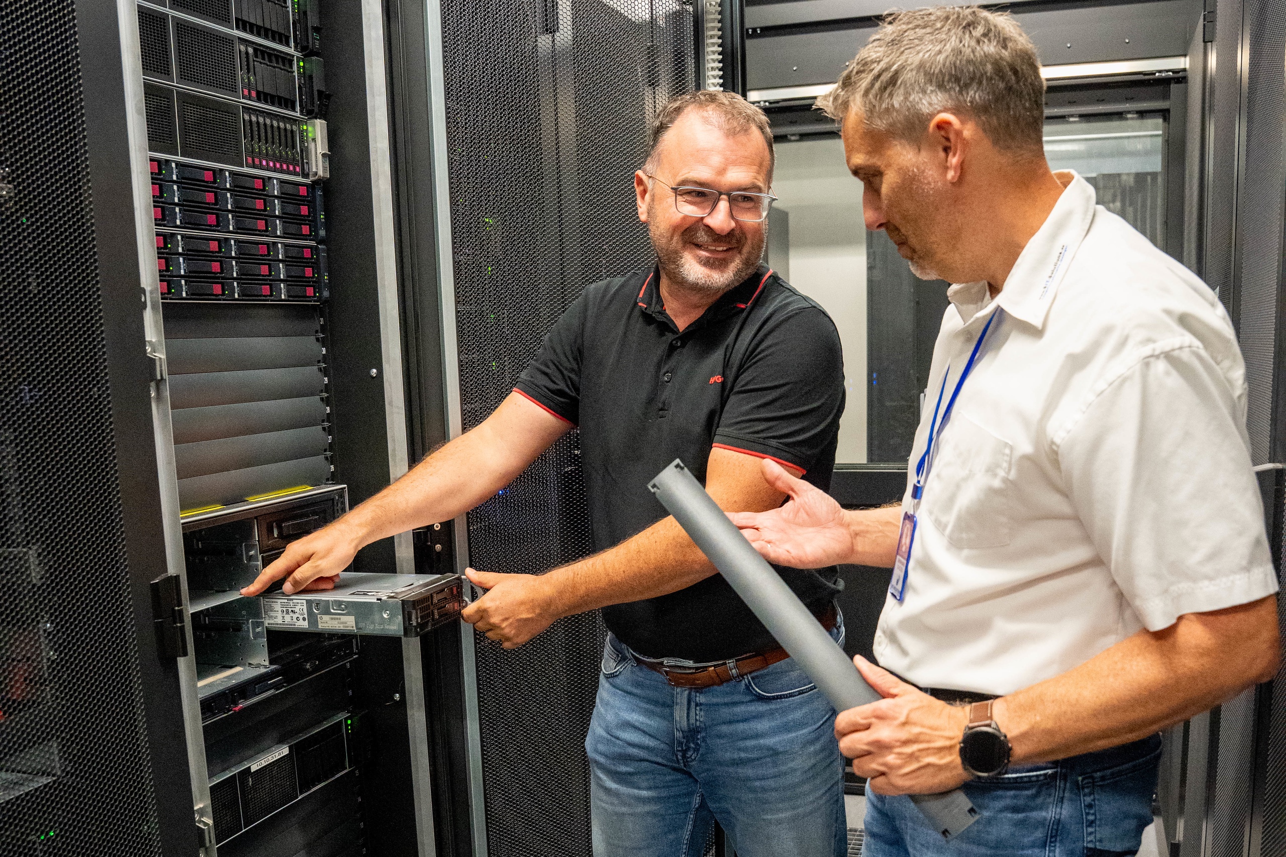 Wolfgang Asbeck zieht einen Server aus dem Rack, Bernhard Schlögl hilft